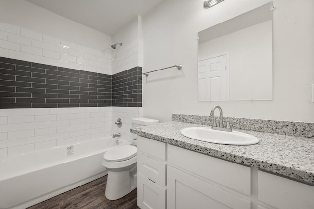 full bathroom with vanity, hardwood / wood-style floors, tiled shower / bath combo, and toilet