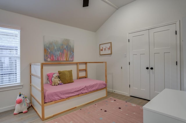 bedroom with ceiling fan, lofted ceiling, light hardwood / wood-style floors, and a closet