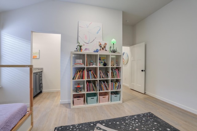 interior space featuring lofted ceiling and light hardwood / wood-style flooring