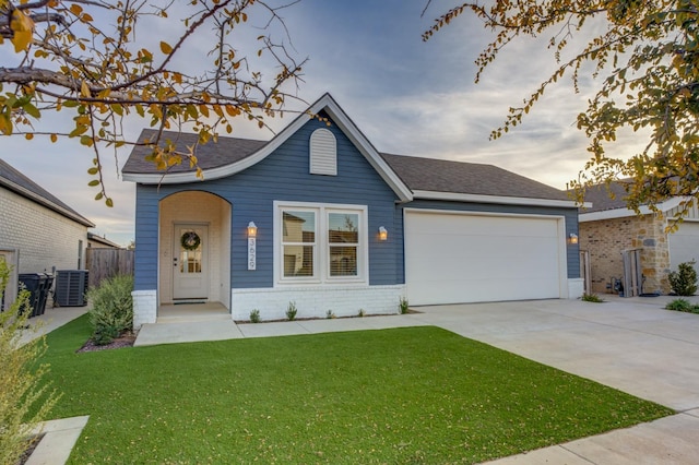 view of front of home featuring a garage, central AC unit, and a lawn