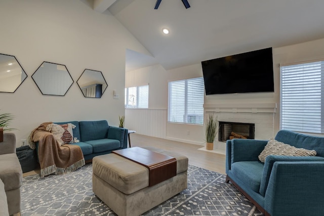 living room featuring ceiling fan, dark hardwood / wood-style floors, high vaulted ceiling, and a brick fireplace