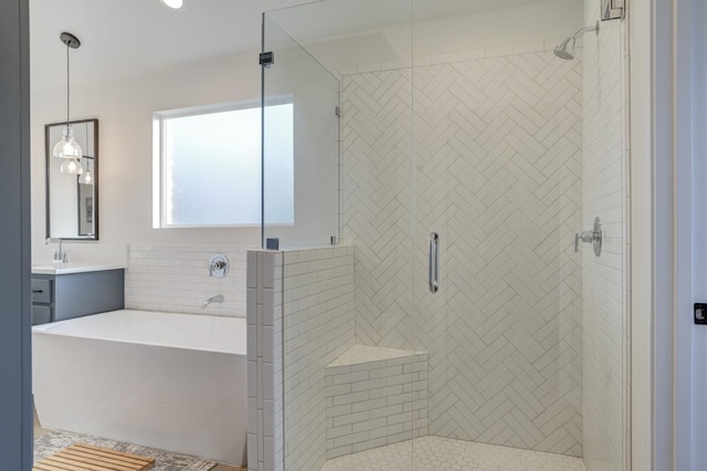 bathroom featuring vanity and independent shower and bath