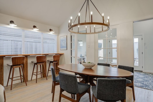 dining space with vaulted ceiling and light hardwood / wood-style flooring