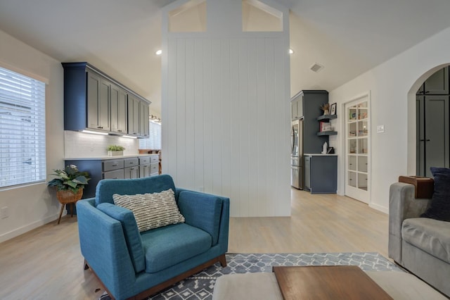 living room featuring lofted ceiling and light hardwood / wood-style floors