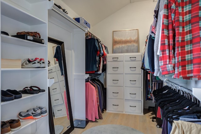 walk in closet with lofted ceiling and light hardwood / wood-style floors