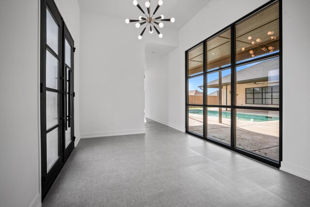4803 120th St, Lubbock, TX 79424 - unfurnished room featuring a chandelier, baseboards, and floor to ceiling windows
