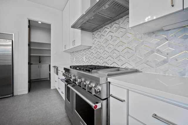 4803 120th St, Lubbock, TX 79424 - kitchen featuring high quality appliances, exhaust hood, white cabinetry, light countertops, and decorative backsplash