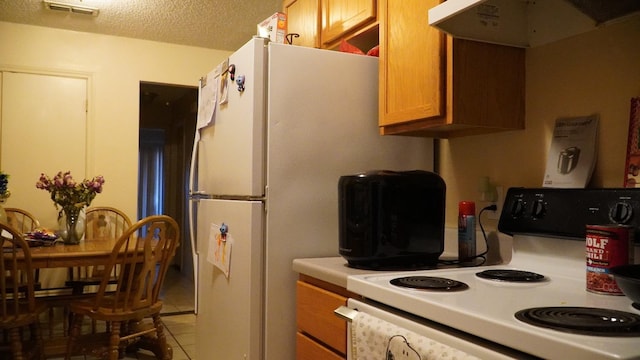 kitchen featuring white electric range oven, a textured ceiling, and light tile patterned floors