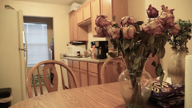 kitchen featuring white appliances and light brown cabinets