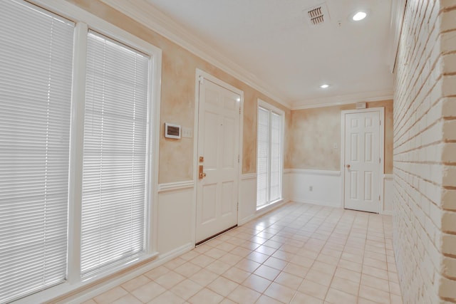 tiled foyer entrance featuring ornamental molding