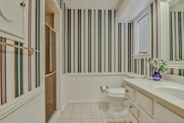 bathroom featuring tile patterned floors, toilet, a shower with shower door, and vanity