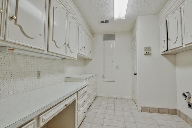 laundry room with light tile patterned floors and a textured ceiling