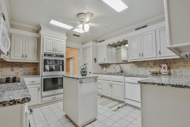 kitchen featuring a kitchen island, white cabinetry, dishwasher, sink, and stainless steel double oven