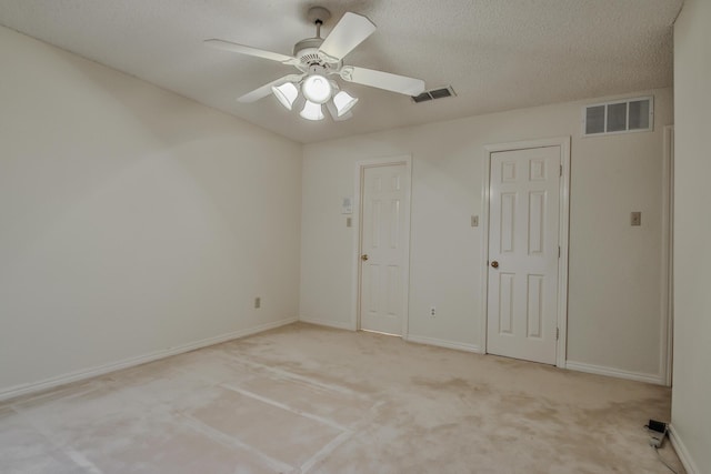 unfurnished bedroom with ceiling fan, light colored carpet, and a textured ceiling