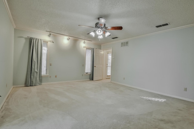 unfurnished room featuring ceiling fan, crown molding, light colored carpet, and a textured ceiling