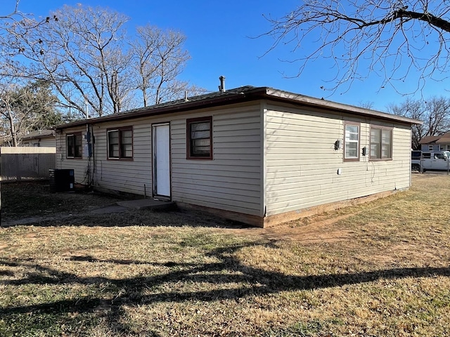 back of property featuring a lawn and central air condition unit