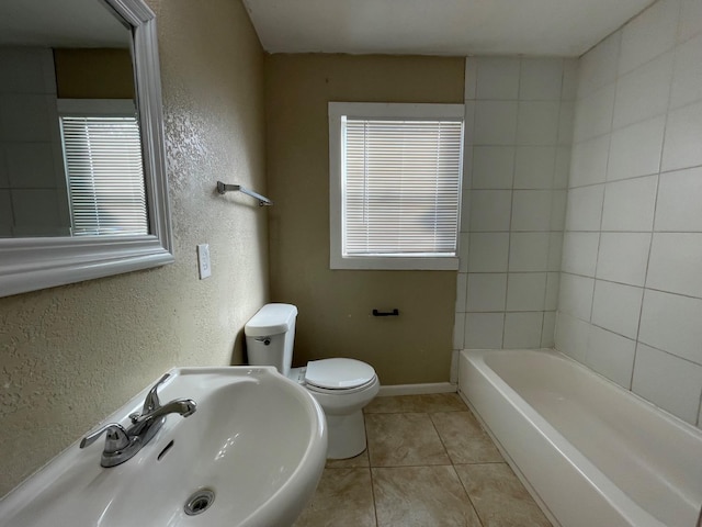 bathroom with a healthy amount of sunlight, toilet, tile patterned flooring, and sink