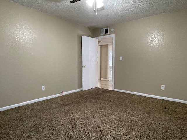 carpeted empty room featuring ceiling fan and a textured ceiling