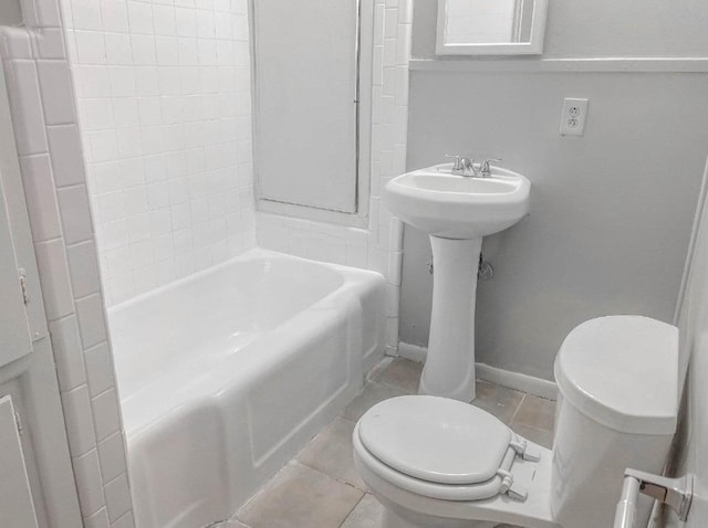 bathroom featuring tile patterned flooring, tub / shower combination, and toilet