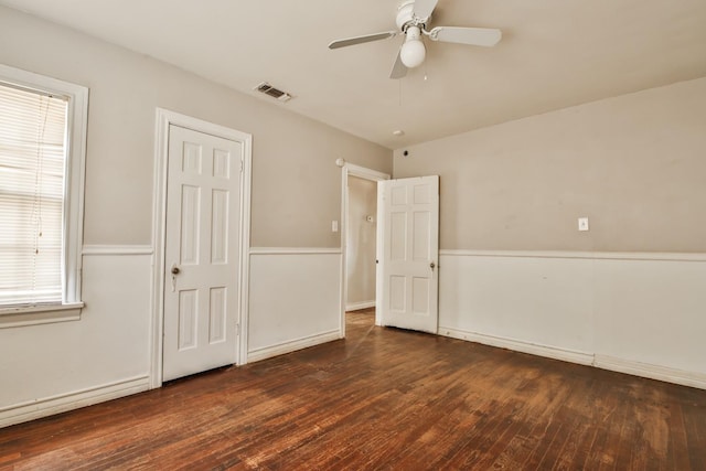 unfurnished bedroom featuring dark wood-type flooring and ceiling fan