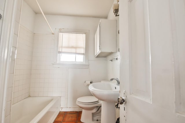 bathroom featuring tile patterned flooring, tiled shower / bath, and toilet