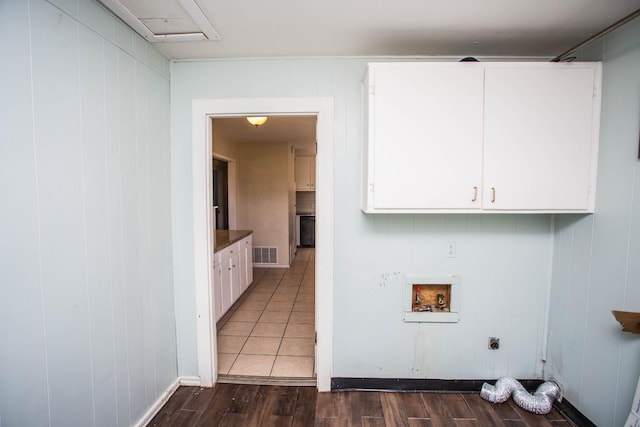 washroom with hookup for a washing machine, dark wood-type flooring, and cabinets