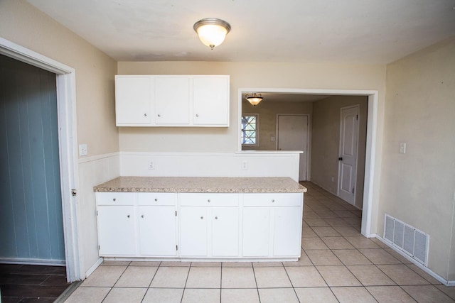 kitchen featuring white cabinetry and light tile patterned floors