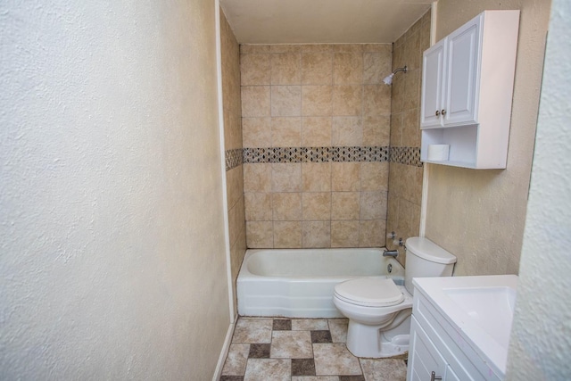 full bathroom featuring vanity, tiled shower / bath combo, and toilet