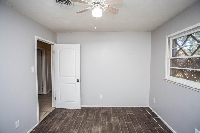 unfurnished room featuring dark hardwood / wood-style floors and ceiling fan