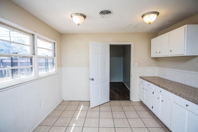 kitchen with white cabinetry and light tile patterned flooring