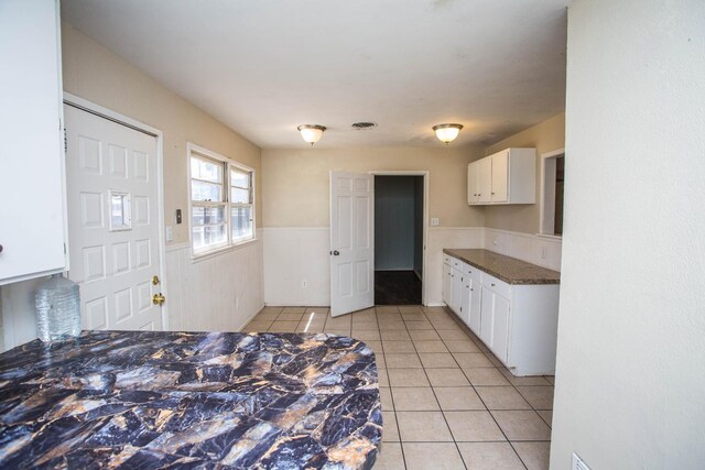 kitchen featuring white cabinets and light tile patterned flooring