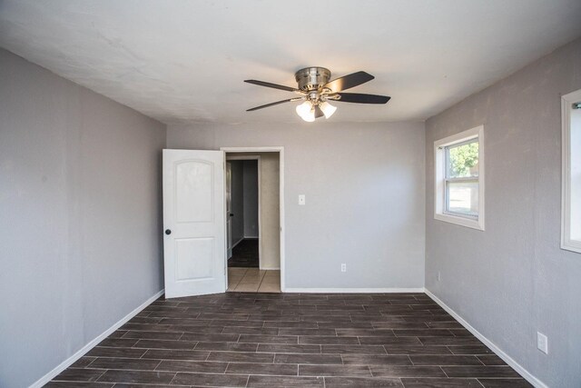 spare room with dark hardwood / wood-style floors and ceiling fan