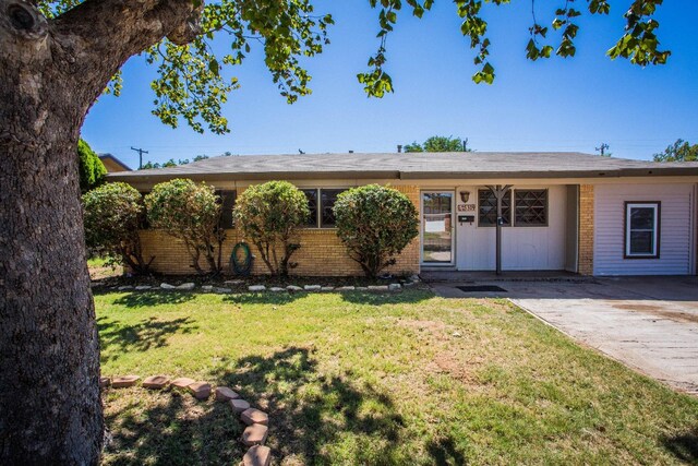 ranch-style home with a front lawn