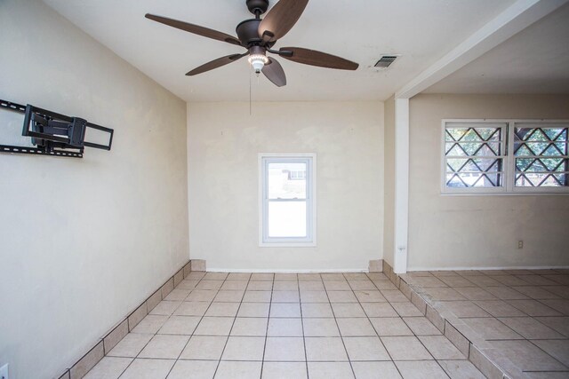 tiled spare room featuring ceiling fan