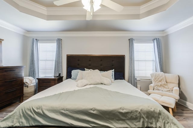 bedroom featuring a raised ceiling, ornamental molding, and ceiling fan