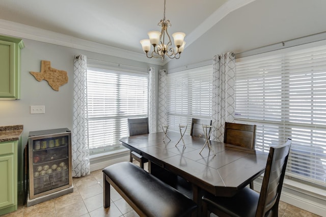 dining room with lofted ceiling, wine cooler, ornamental molding, light tile patterned floors, and a notable chandelier