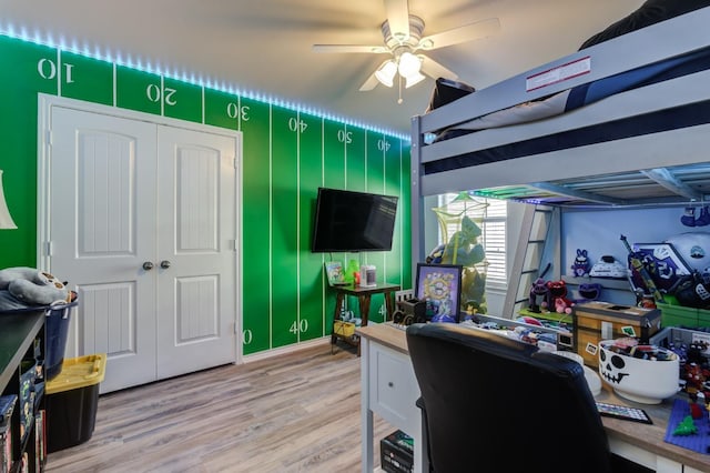 bedroom with hardwood / wood-style flooring, ceiling fan, and a closet