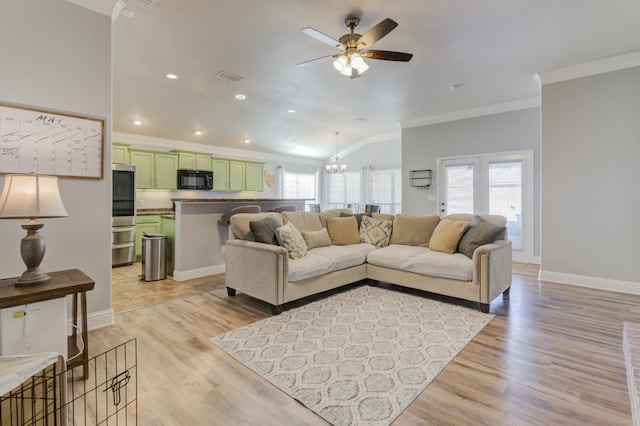 living room with crown molding, vaulted ceiling, and a healthy amount of sunlight