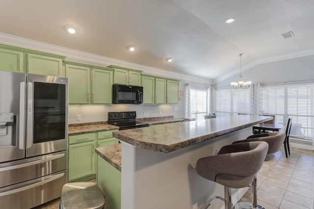 kitchen with lofted ceiling, pendant lighting, green cabinets, black appliances, and a kitchen bar