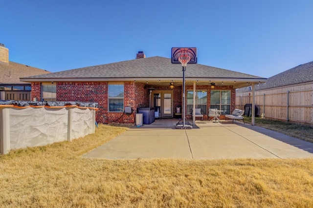 back of property with a yard and a patio area