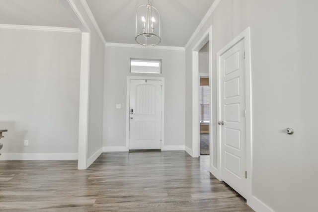 foyer with crown molding, hardwood / wood-style flooring, and a notable chandelier