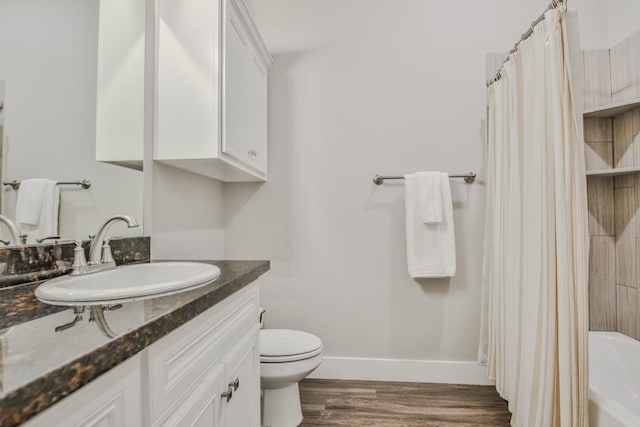 bathroom with wood-type flooring, vanity, and toilet