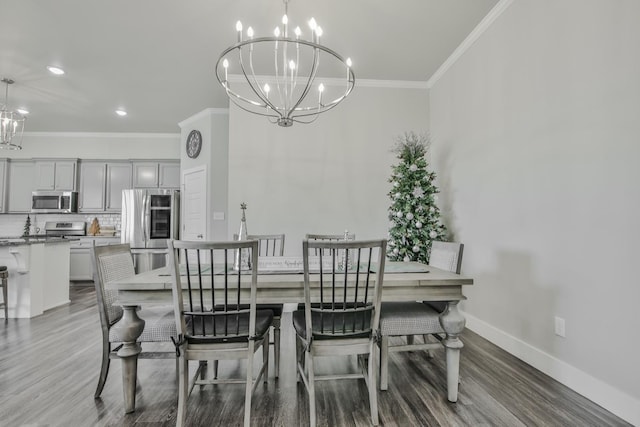 dining area featuring crown molding, hardwood / wood-style floors, and a notable chandelier