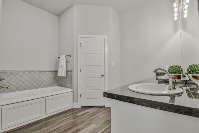 bathroom with vanity, hardwood / wood-style floors, and a tub