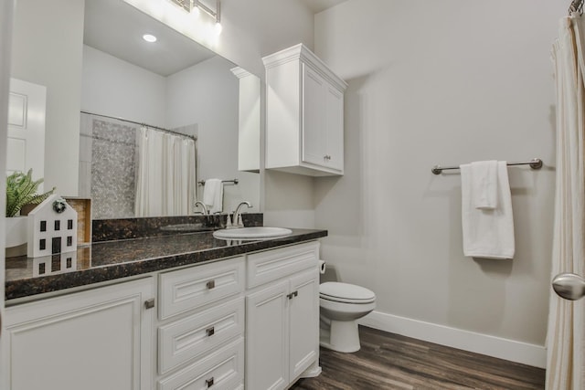 bathroom featuring vanity, hardwood / wood-style floors, a shower with curtain, and toilet