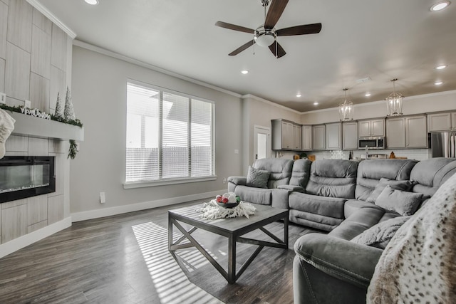 living room featuring ceiling fan, ornamental molding, dark hardwood / wood-style floors, and a tile fireplace