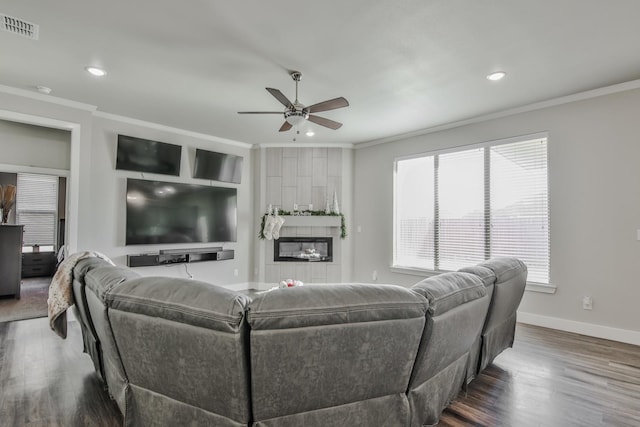 living room with hardwood / wood-style floors, a fireplace, ornamental molding, and a healthy amount of sunlight