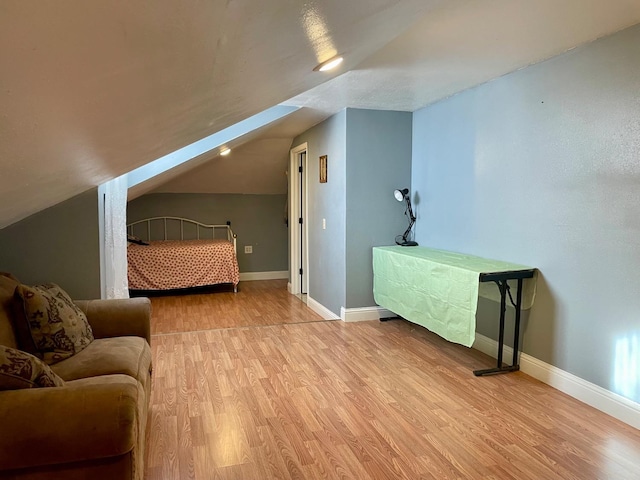 bedroom with lofted ceiling and light wood-type flooring