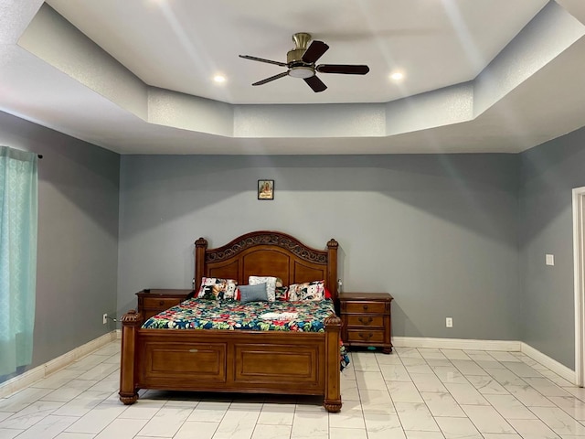 bedroom with a raised ceiling and ceiling fan