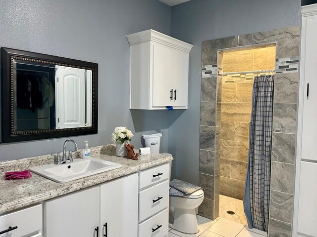 bathroom featuring vanity, curtained shower, tile patterned floors, and toilet